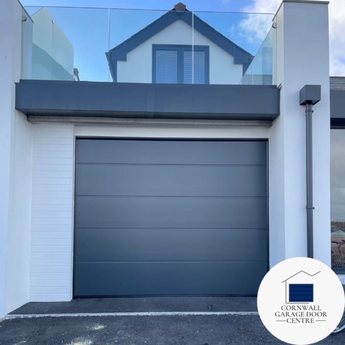 Anthracite grey insulated sectional garage door, featuring a sleek and smooth surface finish. Provides enhanced thermal efficiency and durability for your home. A modern and stylish addition to any property.