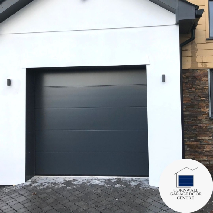 Anthracite Grey Solid Smooth Insulated Sectional Garage Door: A sleek and modern addition to any home. The durable insulated panels provide energy efficiency while the smooth finish adds a touch of elegance. Perfect for enhancing both curb appeal and functionality.