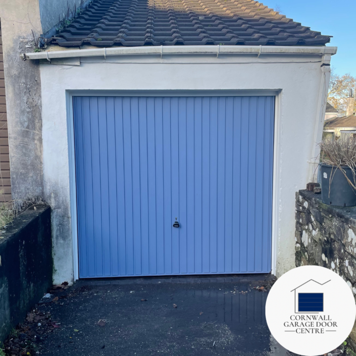 Image showing a Carlton Pigeon blue Blue Up & Over Garage Door, featuring a sleek design with vibrant blue color and the Carlton Pig logo prominently displayed. The door is in the raised position, showcasing its smooth functionality and modern aesthetic.